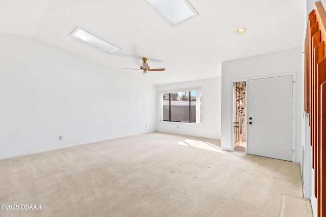 unfurnished room with vaulted ceiling, light colored carpet, and ceiling fan