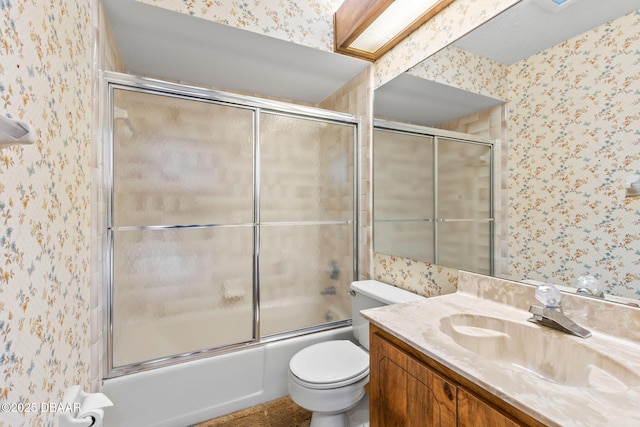 full bathroom featuring vanity, bath / shower combo with glass door, and toilet