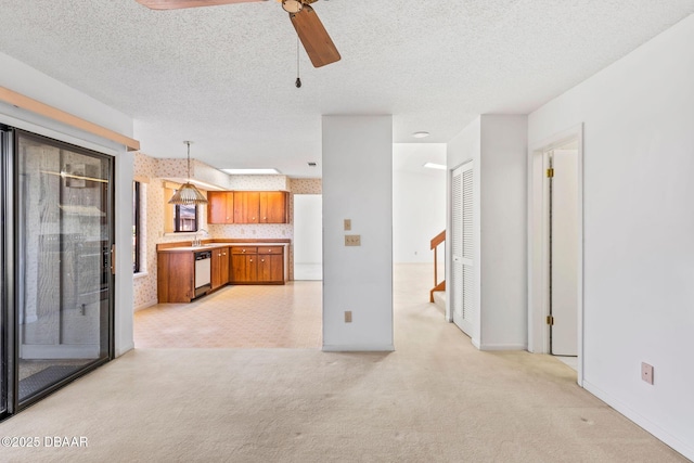 unfurnished living room with light carpet, a textured ceiling, and ceiling fan