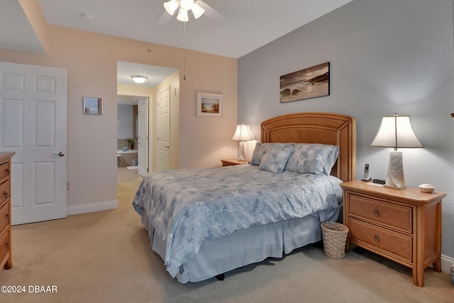 bedroom with light carpet, ceiling fan, and connected bathroom