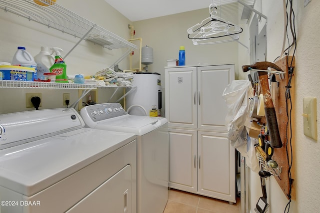 laundry room with cabinets, water heater, light tile patterned floors, and independent washer and dryer