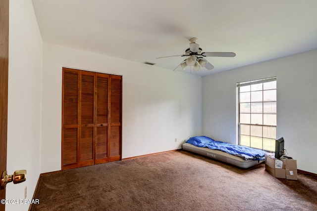 unfurnished bedroom featuring ceiling fan, a closet, and carpet floors