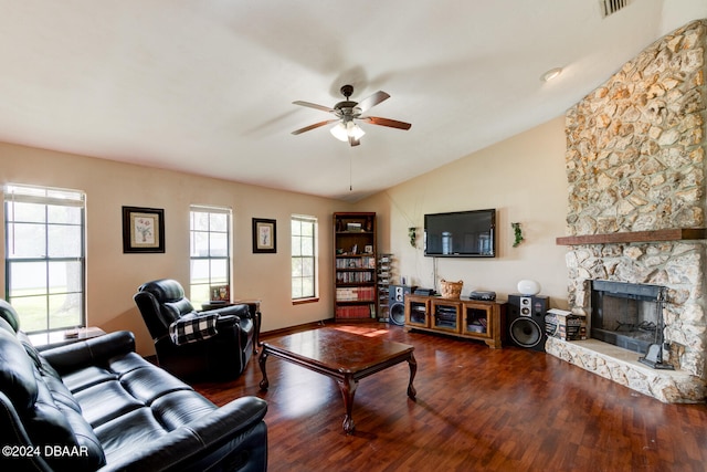 living room with hardwood / wood-style flooring, a stone fireplace, a healthy amount of sunlight, and vaulted ceiling