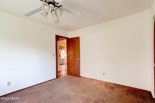 carpeted spare room featuring ceiling fan