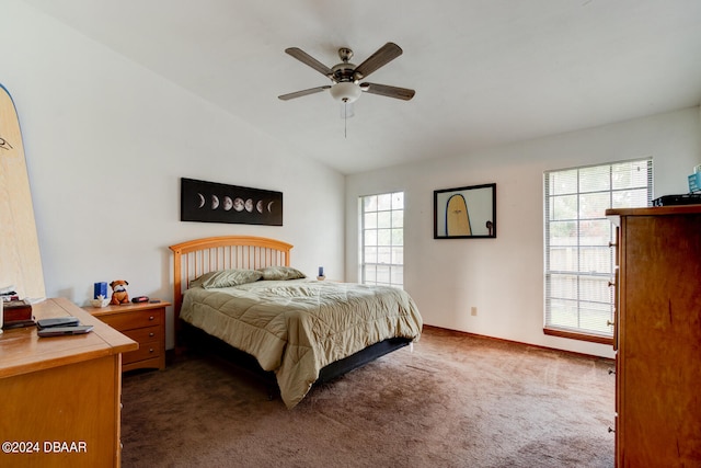 carpeted bedroom featuring multiple windows, ceiling fan, and vaulted ceiling