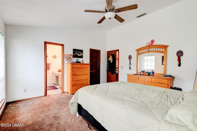 carpeted bedroom featuring a closet, lofted ceiling, ceiling fan, and ensuite bathroom