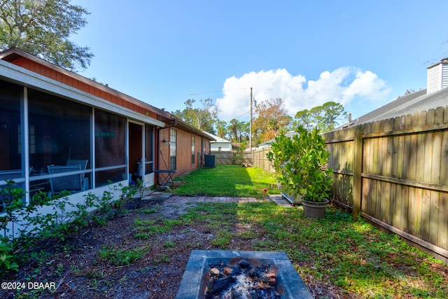 view of yard with central air condition unit and a sunroom