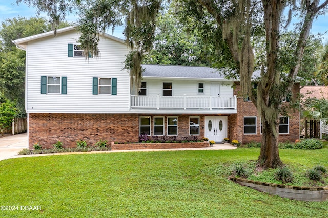 front facade with a balcony and a front yard