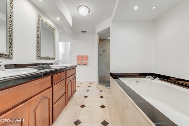 bathroom featuring tile patterned flooring, vanity, and plus walk in shower