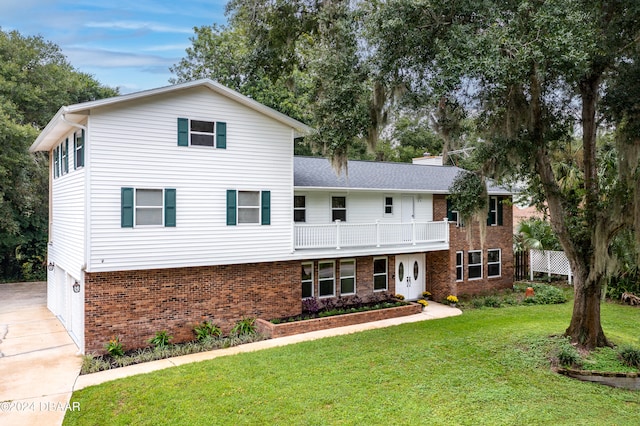 view of front of house with a garage, a front yard, and a balcony