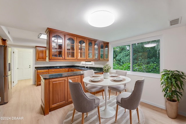 dining space featuring light wood-type flooring and sink