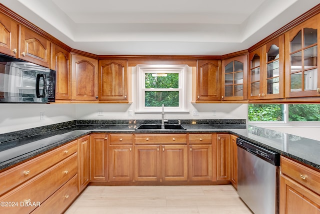 kitchen featuring dishwasher, dark stone counters, sink, and a raised ceiling