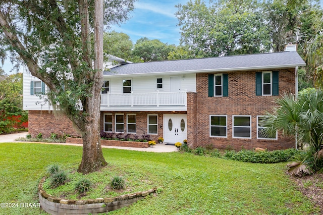 view of front of property with a front yard and a balcony