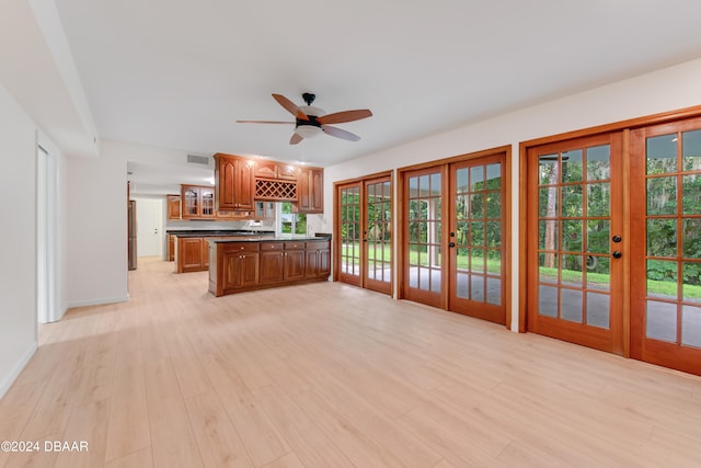 kitchen with french doors, light wood-type flooring, stainless steel refrigerator, kitchen peninsula, and ceiling fan