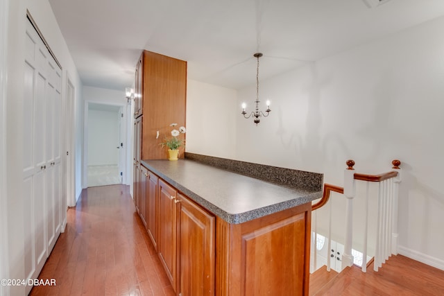 kitchen with pendant lighting, light hardwood / wood-style flooring, and a notable chandelier