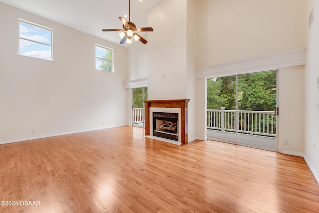 unfurnished living room with ceiling fan, light hardwood / wood-style flooring, and high vaulted ceiling