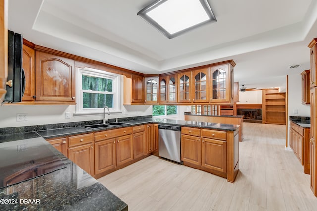 kitchen with sink, kitchen peninsula, a tray ceiling, light wood-type flooring, and dishwasher