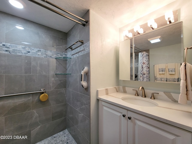 bathroom with walk in shower, vanity, and a textured ceiling