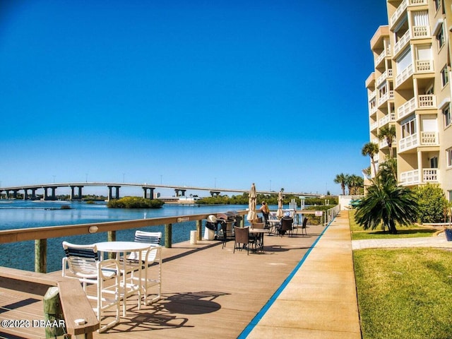 dock area with a water view and a balcony