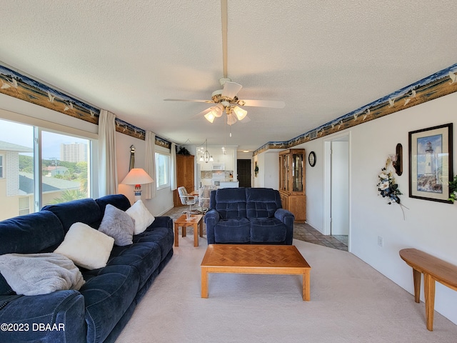 living room with a textured ceiling, light colored carpet, and ceiling fan