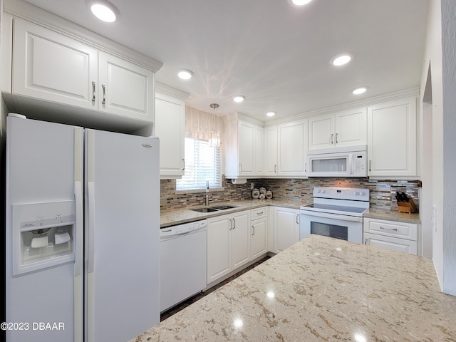 kitchen with white appliances, white cabinetry, sink, and light stone counters