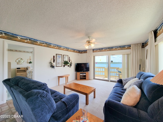 carpeted living room featuring ceiling fan and a textured ceiling