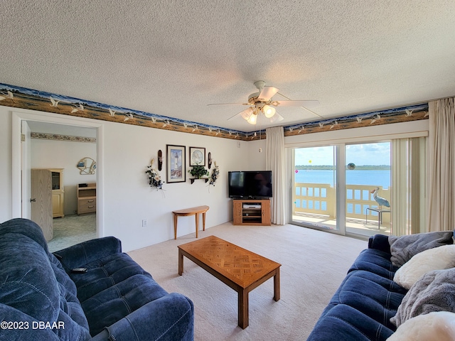 carpeted living room featuring a textured ceiling and ceiling fan