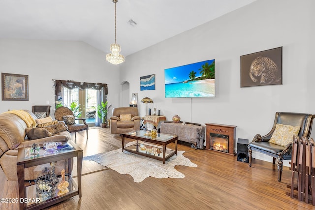 19343 Moorgate St, Orlando, FL 32833 - living room with wood finished floors, a chandelier, high vaulted ceiling, and arched walkways