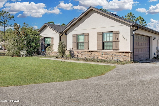 19343 Moorgate St, Orlando, FL 32833 - view of front facade with stone siding, stucco siding, a front yard, and an attached garage