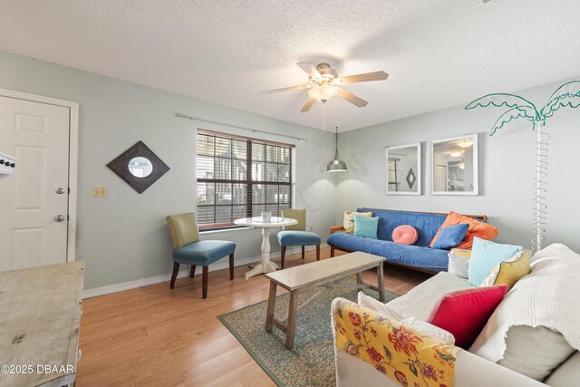 840 Center Ave Unit 21, Holly Hill, FL 32117 - living area featuring baseboards, light wood-style flooring, a textured ceiling, and a ceiling fan