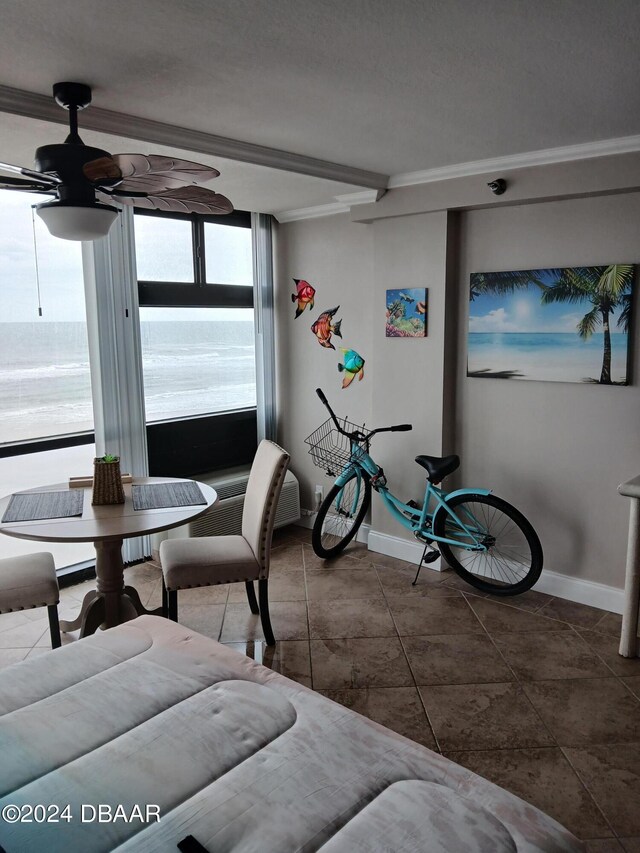 interior space with ornamental molding, ceiling fan, and tile patterned floors