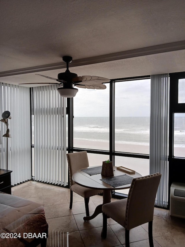 sunroom / solarium featuring ceiling fan and a water view