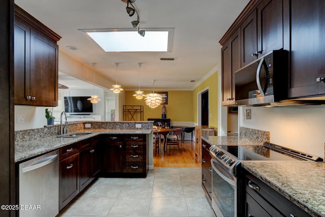 kitchen featuring visible vents, appliances with stainless steel finishes, a peninsula, pendant lighting, and a sink