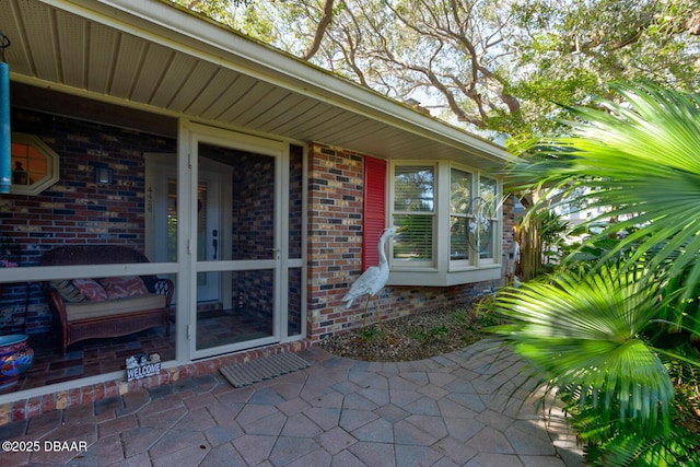 property entrance featuring brick siding and a patio area