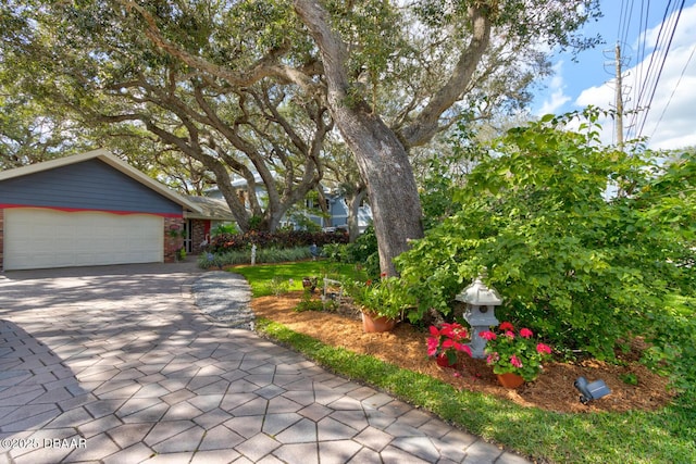 view of front of home with a garage and decorative driveway