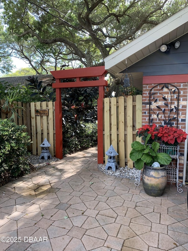 view of patio featuring fence and a gate