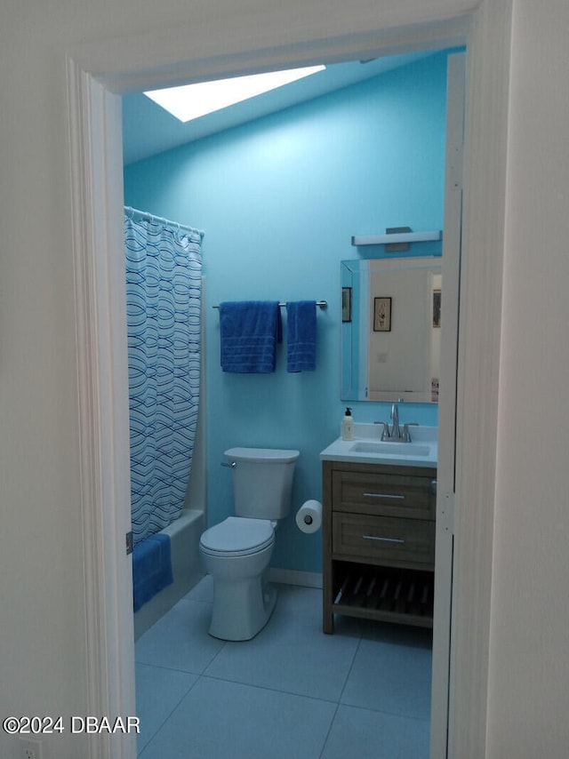 full bathroom featuring vanity, shower / bath combination with curtain, a skylight, tile patterned flooring, and toilet