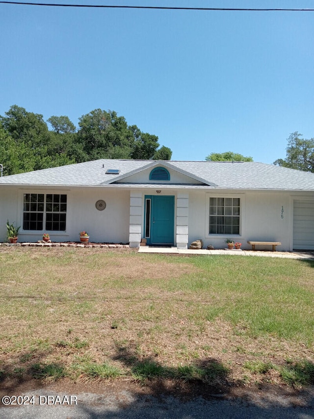 ranch-style home with a garage and a front yard