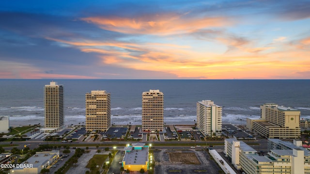 aerial view at dusk featuring a water view