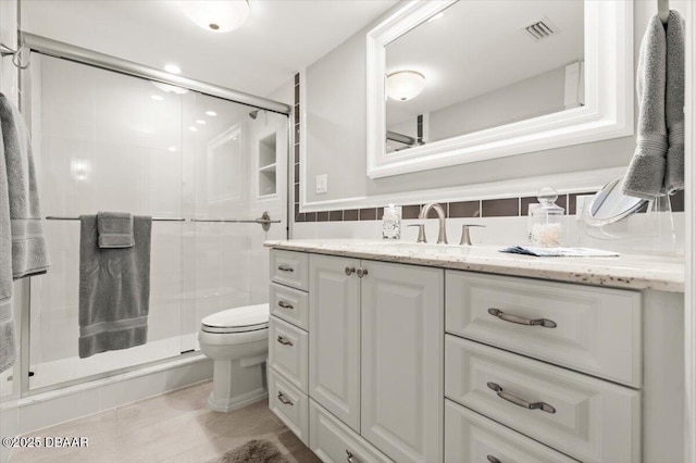 bathroom with tile walls, vanity, tile patterned floors, toilet, and walk in shower