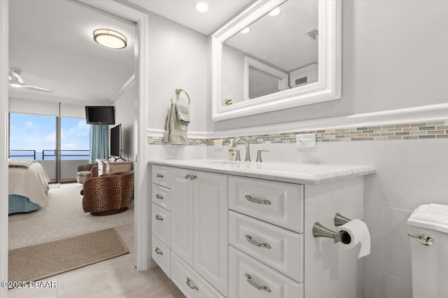 bathroom with vanity, tile walls, and ceiling fan