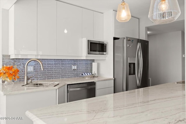 kitchen featuring white cabinetry, light stone counters, and appliances with stainless steel finishes