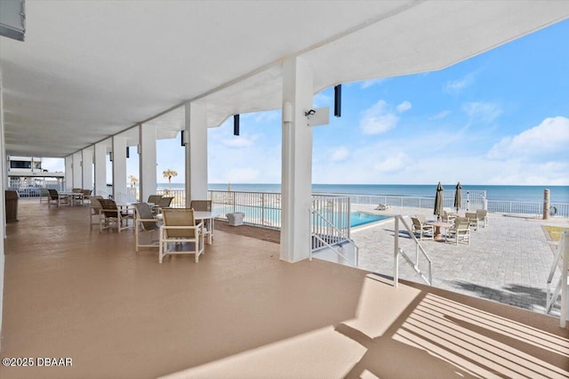 view of patio / terrace with a water view and a view of the beach