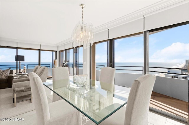 dining room with ornamental molding, a water view, and a notable chandelier