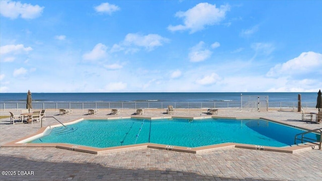 view of pool with a patio and a water view