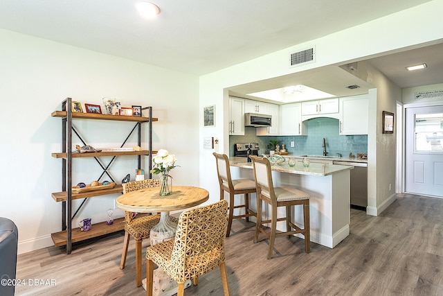 dining space with hardwood / wood-style floors and sink