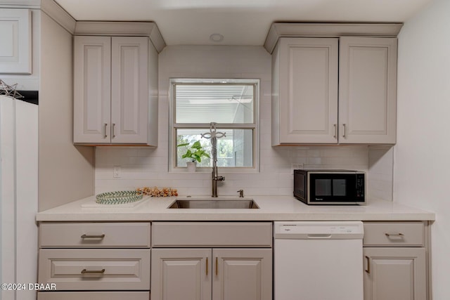 kitchen with tasteful backsplash, sink, white cabinets, and white appliances