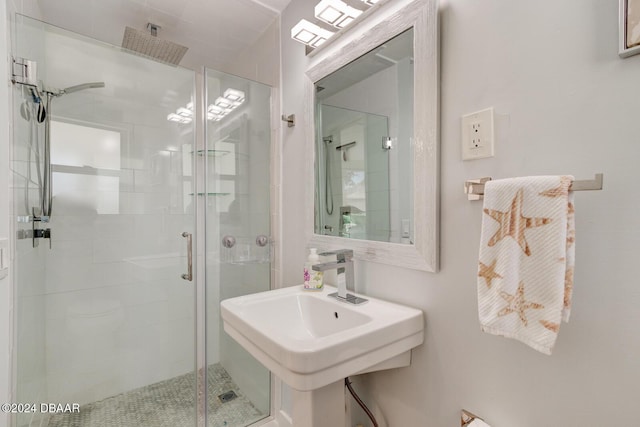 bathroom featuring sink and a shower with shower door