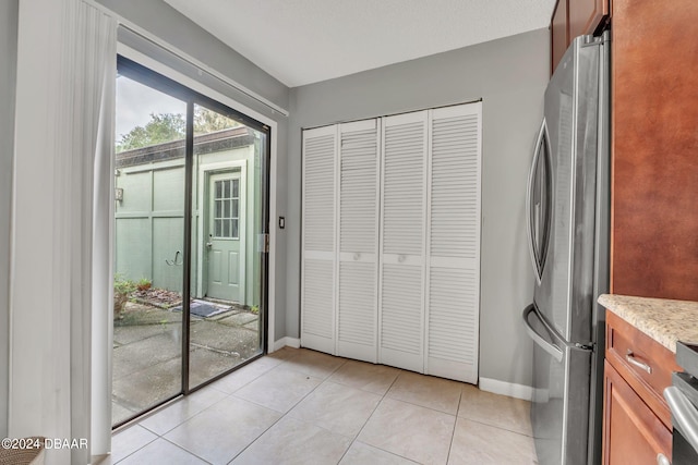 kitchen with light tile patterned flooring and stainless steel fridge