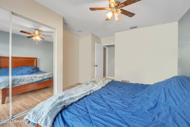 bedroom featuring hardwood / wood-style flooring, ceiling fan, and a closet